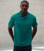 Henbury H475 Coolplus wicking piqué polo shirt in Bright Jade, worn by a model