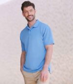 Henbury H475 Coolplus wicking piqué polo shirt in Mid Blue, worn by a model